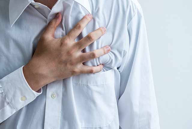 胸に手を当てる男性の胸元